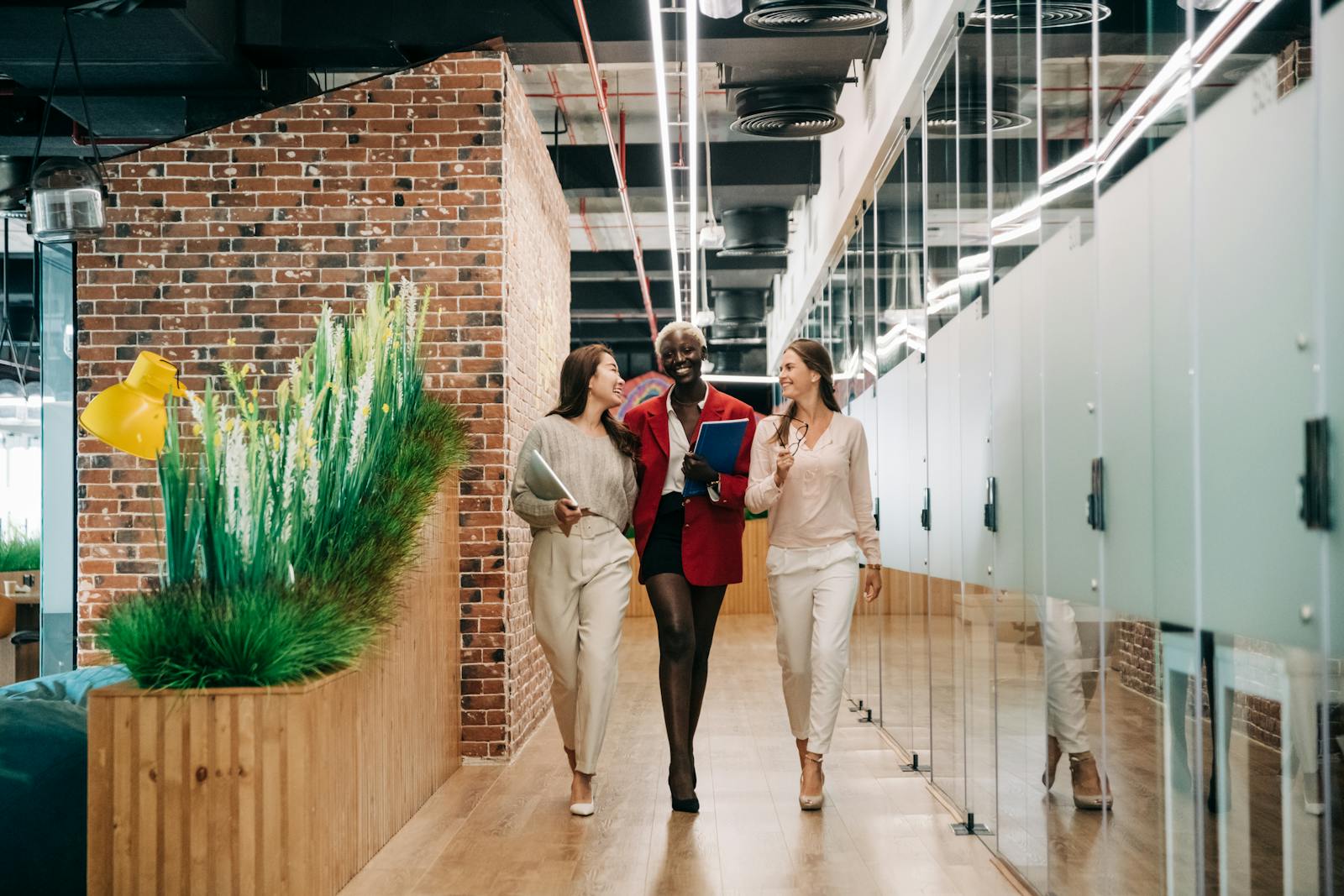 Multiethnic businesswomen walking and discussing successful project in contemporary office